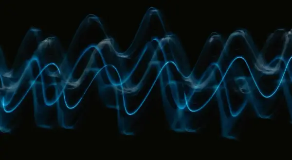 Abstract blue light trails form wave patterns on a black background, visualizing the sound waves that play wav files.