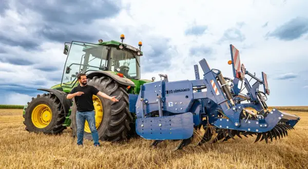 Un homme présente une charrue Rolmako, un outil agricole essentiel pour préparer les sols. La sep charrue définition est ici illustrée par cet équipement robuste.