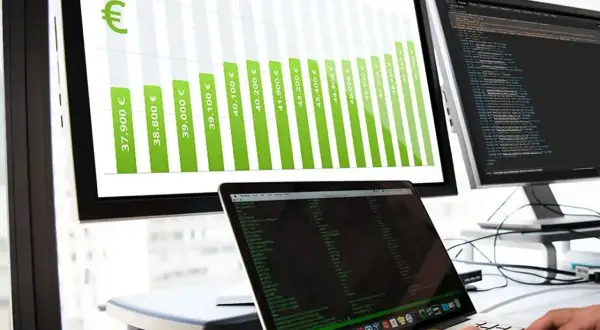 Balkendiagramm zeigt steigende Gehälter für Informatiker, von 37.900 € bis über 50.000 €. Ein Laptop mit Code ist im Vordergrund zu sehen.