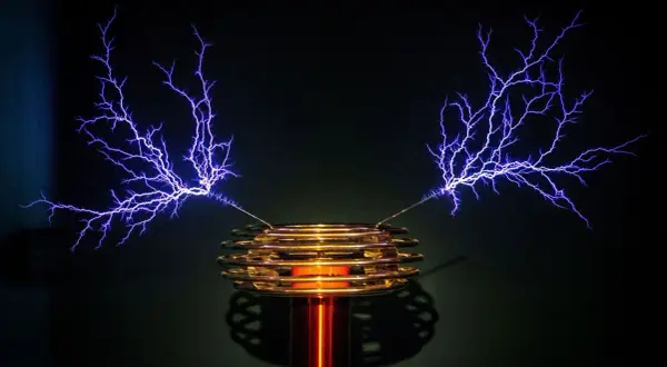 Cewka Tesli generuje fioletowe wyładowania elektryczne przypominające drzewa.