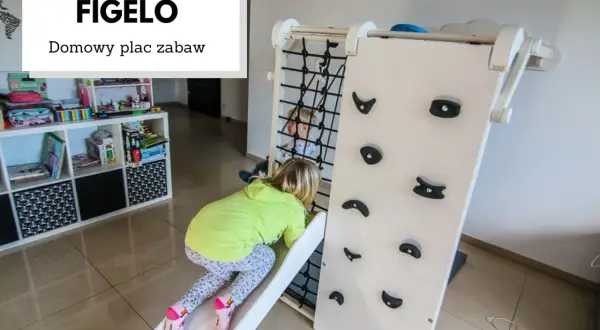 Dzieci bawią się na domowym placu zabaw Figelo. Dziewczynka zjeżdża ze zjeżdżalni, a chłopiec jest w środku konstrukcji.