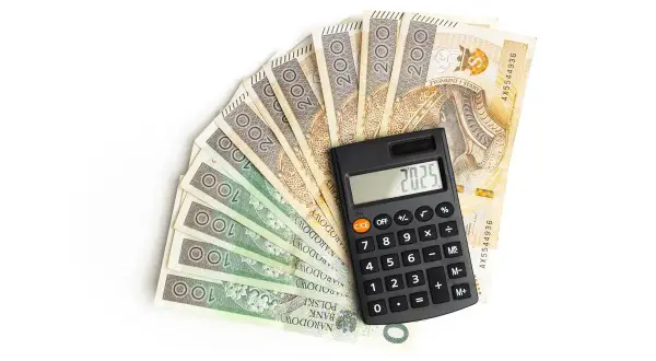Kalkulator na tle polskich banknotów 100 i 200 zł.