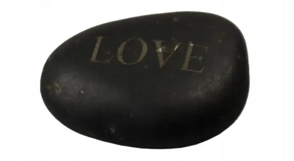Czarny, gładki kamień z wygrawerowanym napisem "LOVE". Dałem ci kamień z wielkim love tekst, jako symbol naszej więzi.