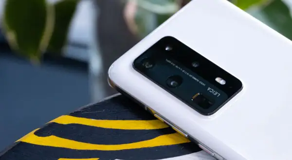 Biały smartfon z aparatem Leica na pokładzie, działający na systemie emui 10.1, leży na ozdobnej powierzchni.