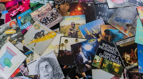 Bunte Schallplatten zeigen, welche Musikrichtungen es gibt: Rock von AC/DC, Pop von Genesis, Reggae von Bob Marley und mehr.
