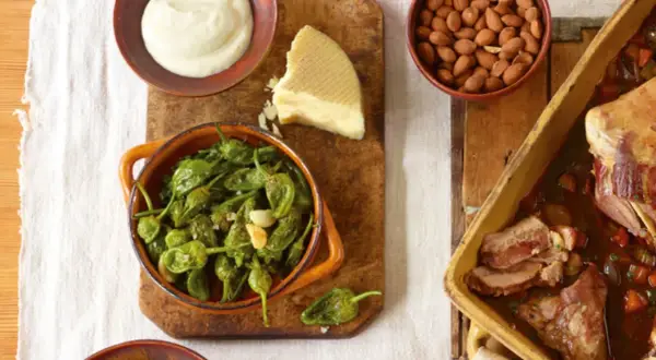 Eine **spanische Tapas Liste** mit gebratenen Pimientos, Mandeln, Käse und einem Braten.
