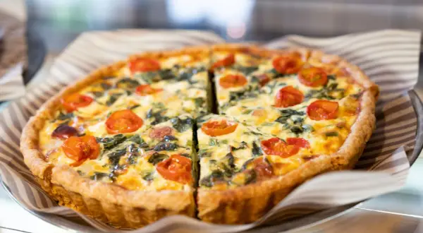 Torta salata con pomodorini e spinaci, perfetta per il tempo di cottura torta salata forno ventilato. Dorata e invitante.
