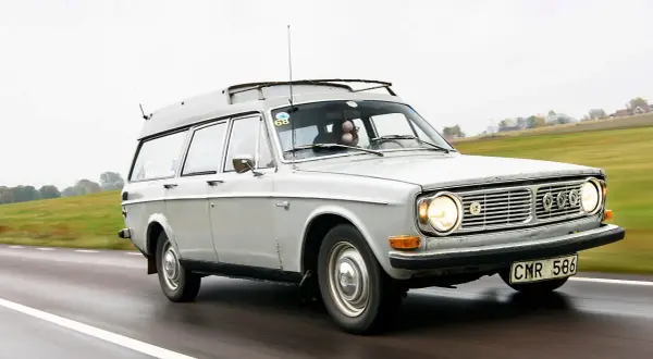 Grå Volvo 145 Express med takräcke kör på en väg.