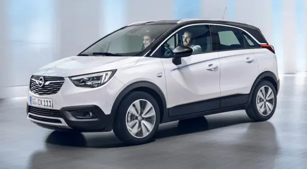 Biały Opel Crossland z parą uśmiechniętych ludzi w środku. Sprawdź atrakcyjną opel crossland cena!