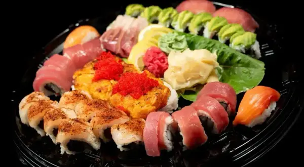 Talerz sushi z różnymi rolkami, nigiri i sashimi. Wyobraź sobie, jak smakuje sushi: świeża ryba, ryż i chrupiące dodatki.