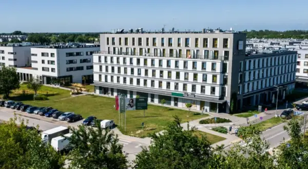 Nowoczesny waw airport hotel z parkingiem i zielonym otoczeniem.