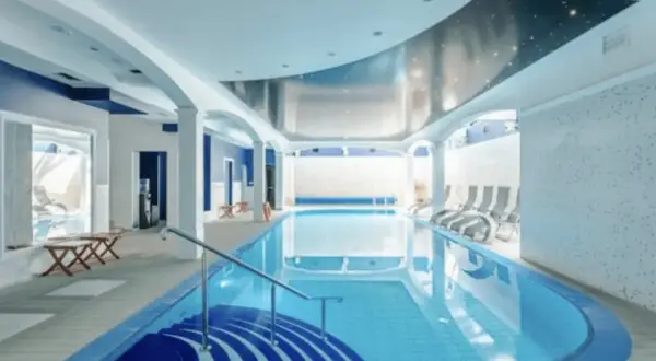 Basen w hotelu z niebieskimi akcentami i sufitem imitującym nocne niebo. Idealne miejsce dla najlepszych hoteli nad morzem w Polsce.
