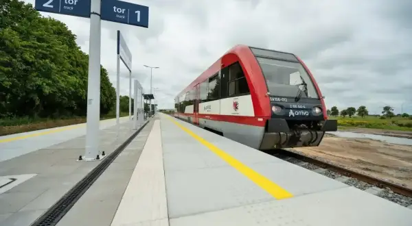 Czerwony pociąg Arriva czeka na peronie. Tablice wskazują tor 1 i tor 2, sugerując podróż między Toruniem a Lublinem.