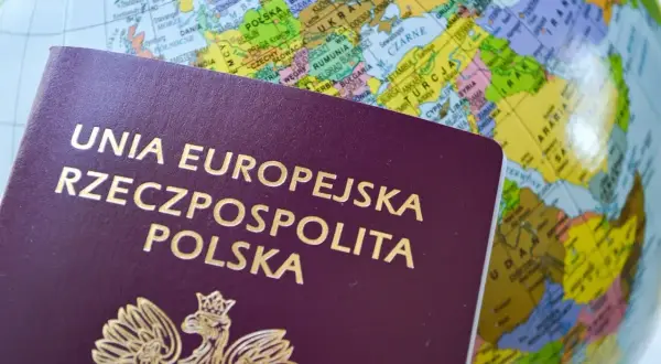 Polski paszport na tle globusa pokazuje, ile ważny jest paszport dla podróżowania po świecie.