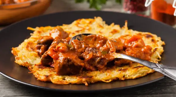 Gulasz do placka po węgiersku, bogaty i aromatyczny, podany na chrupiącym placku ziemniaczanym.