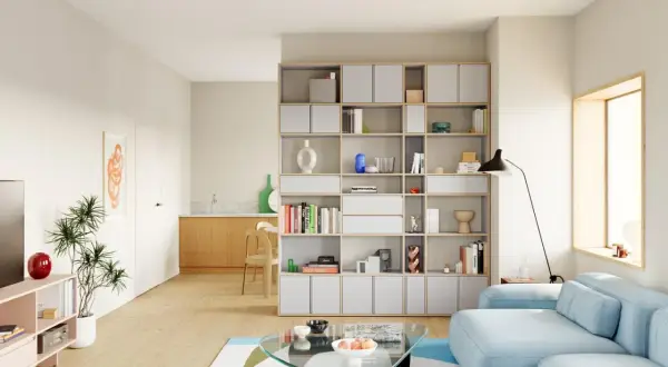 Helle, moderne wohnzimmer inspiration mit einem blauen Sofa, einem Glas-Couchtisch und einem großen Regal voller Bücher und Deko.