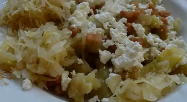 Szare kluchy z kapustą po poznańsku, posypane białym serem i skwarkami. Pyszne danie, które smakuje jak u babci.