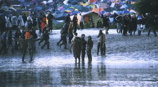 Muddy field with tents and people at Radiohead's iconic Glastonbury 1997 performance.