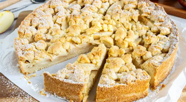 Ein saftiger Apfel-Streuselkuchen, perfekt für den sonntagskuchen schnell und einfach. Mit Puderzucker bestäubt und frisch angeschnitten.