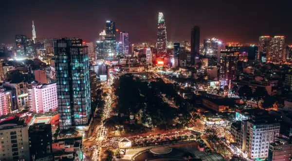 Nocna panorama tętniącego życiem miasta, dawna nazwa miasta Ho Chi Minh, z oświetlonymi drapaczami chmur i ulicami pełnymi ruchu.