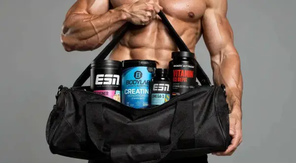 Muskulöser Mann trägt Sporttasche mit Creatin, Omega-3 und Vitamin D Depot – ideal für den Muskelaufbau.