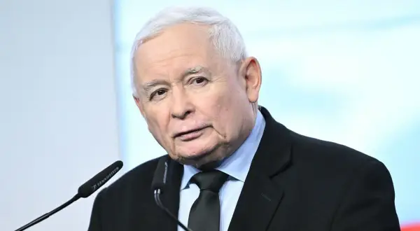 Jarosław Kaczyński, polityk, przemawia przy mikrofonie. Wiek polityka to ważna informacja dla wielu.