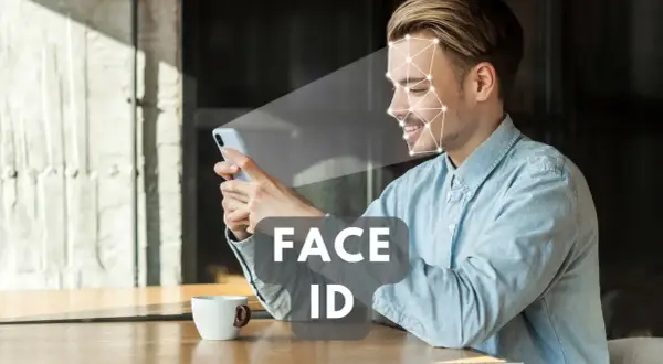Uśmiechnięty mężczyzna korzysta z telefonu, który skanuje jego twarz. Technologia Face ID zapewnia szybki dostęp.