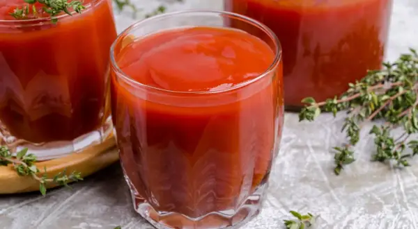 Gęsty, czerwony sok pomidorowy w szklankach, idealny na orzeźwienie. Gałązki tymianku dodają aromatu.