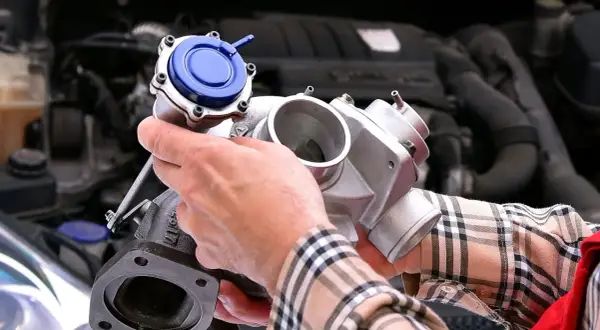 Mechanik pokazuje turbosprężarkę, element kluczowy dla czujnika ciśnienia doładowania. Gdzie się znajduje? W silniku!