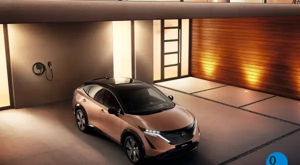 Nissan Ariya color cobre, listo para cargar en un garaje moderno.