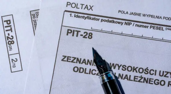 Formularz PIT-28, który służy do rozliczenia przychodów z najmu, leży obok pióra.