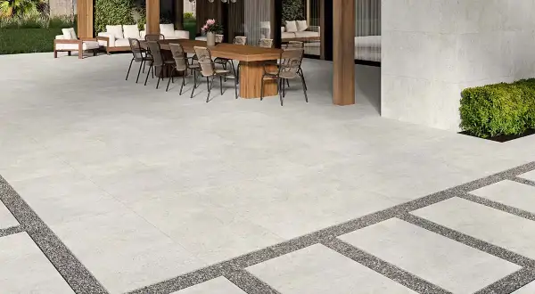 Terraza moderna con suelo de porcelánico que es resistente y elegante, rodeada de vegetación y mobiliario exterior.