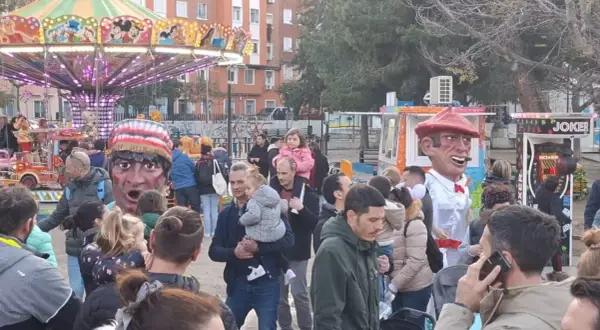 Gigantes y cabezudos animan las fiestas San José Zaragoza. Un carrusel y puestos de feria completan la escena festiva.