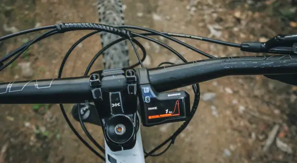 Widok na kierownicę roweru elektrycznego z wyświetlaczem Shimano. Dowiedz się, jak jeździć rowerem elektrycznym, korzystając z trybu ECO.