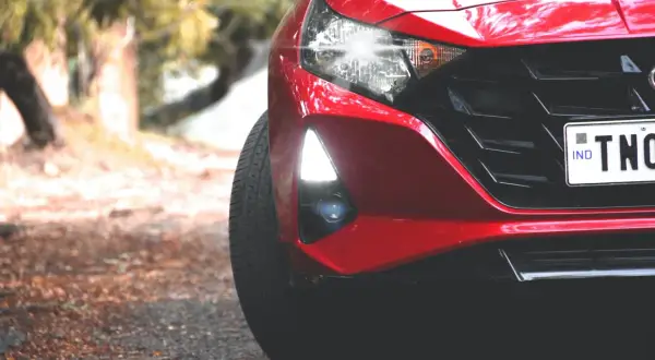 Czerwony Hyundai i20 z zapaloną żarówką do jazdy dziennej, gotowy do drogi.