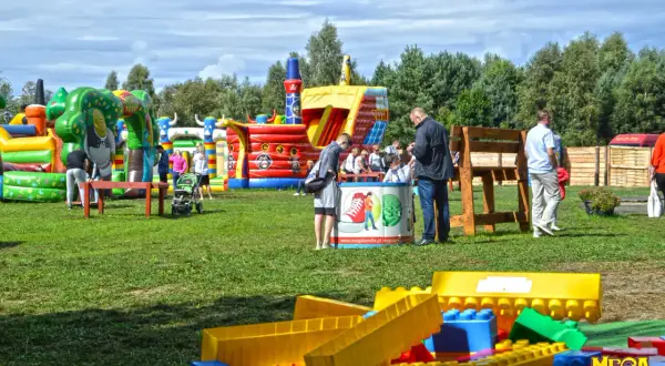 Kolorowe dmuchańce i plac zabaw tworzą wspaniałe ustka atrakcje dla dzieci. Rodziny cieszą się słońcem i zabawą.