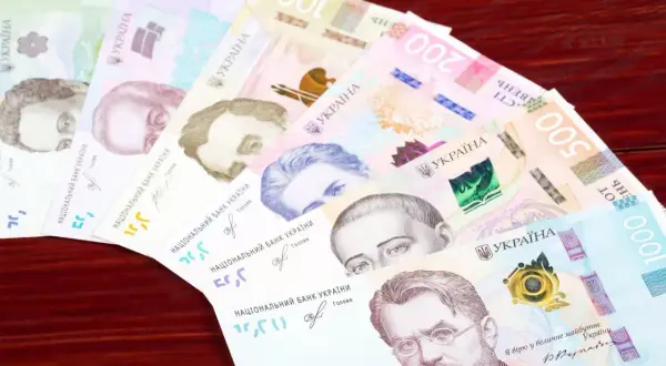 Ukraińska waluta, hrywny, ułożone wachlarzowo na drewnianym tle. Widoczne nominały 20, 50, 100, 200, 500 i 1000.