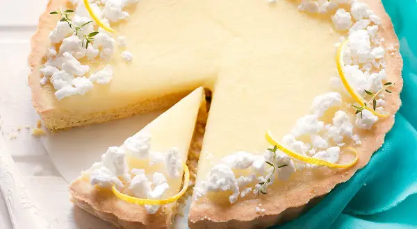 Deliziosa crostata al limone con meringhe e scorzette, una fetta è già stata servita.