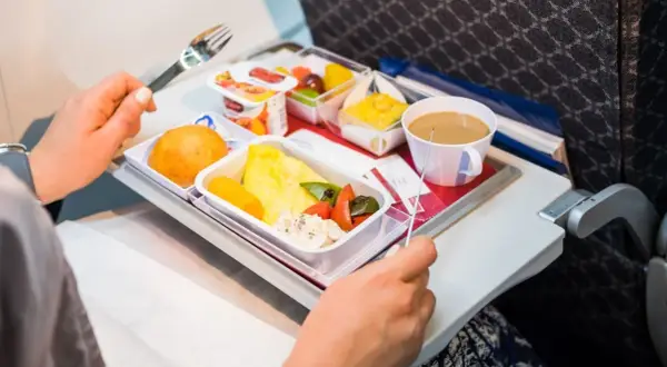 Un pasto aereo con omelette, verdure, pane e caffè. Si può portare cibo in aereo, e questo è un esempio di come viene servito.