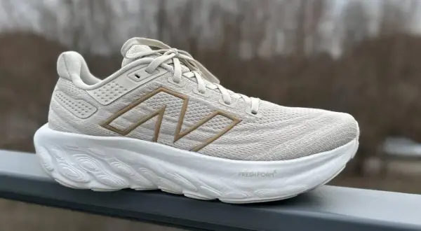Jasny beżowy but sportowy z grubą białą podeszwą. Widoczny napis "Fresh Foam" i logo "N". To pokazuje, co to jest drop w butach – różnica wysokości między piętą a palcami.