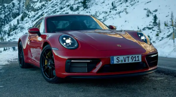 Czerwone Porsche GTS 911 na tle ośnieżonych gór.