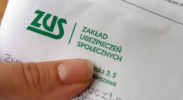Palec wskazujący na dokumencie ZUS, potwierdzającym ubezpieczenie wypadkowe.