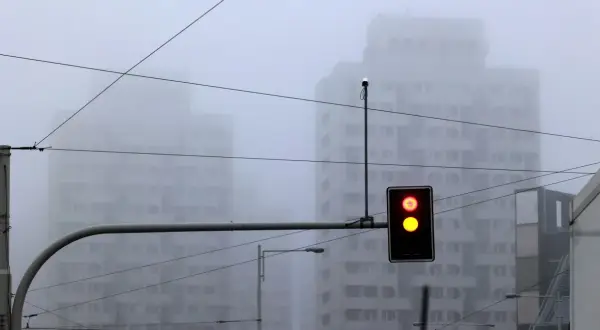Mgła tak gęsta, że czuć ją w powietrzu. Sygnalizacja świetlna pokazuje czerwone i żółte światło, budynki znikają we mgle.