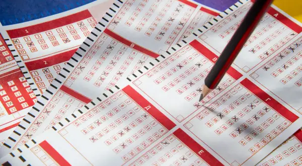 Ktoś zaznacza liczby na kuponach lotto ołówkiem. Czy pracownicy kolektur mogą legalnie drapać losy w godzinach pracy?