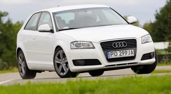 Białe Audi A3 8P w ruchu, z widoczną żarówką stopu.
