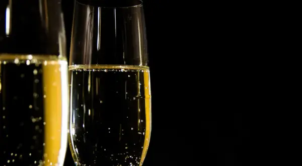 Två glas med bubblande champagne redo att utbringa en skål.