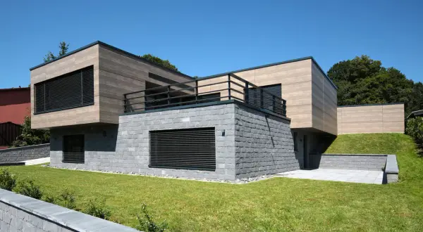 Nowoczesna bryła domu z kamienną podstawą i drewnianą fasadą. Elegancka fasada co to? To wizytówka budynku.