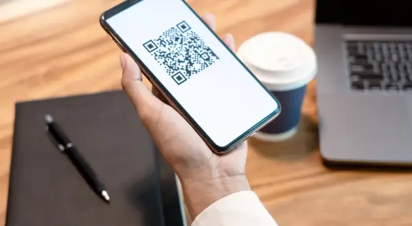 Smartphone con QR code per l'invalidità civile.