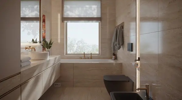 Nowoczesna łazienka z oknem na wprost drzwi, wanna, czarna miska WC i bidet, kamienne płytki, złote baterie.