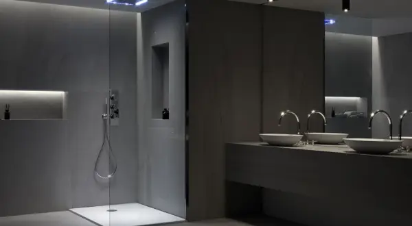 Modernos baños con ventana en la ducha, grifería empotrada y lavabos sobre encimera.